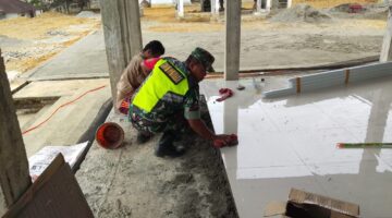 Babinsa koramil 04/Beutong Bantu pembangunan pasang keramik Lantai teras Rumah warga Desa Binaan nya