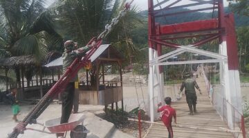 Babinsa Bersama Warga Laksanakan Pengecatan Besi Pylon dan Tali Sling Jembatan Gantung Perintis