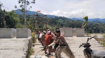 Babinsa Bersama Anggota Yon TP 855/RD Bersama Warga Masyarakat Pasang dan Tarik Tali Sling Jembatan Gantung
