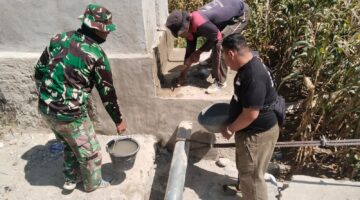 Babinsa dan Warga Cor Rangkai Besi Tali Sling Pondasi Jembatan Gantung Perintis