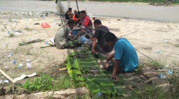 Kebersamaan TNI dan Masyarakat Terjalin Saat Istirahat Makan Siang Dilokasi Pembangunan Jembatan Gantung Perintis