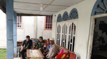 Babinsa Serda Zulkarnen Gelar Komsos Bersama Tokoh Masyarakat Desa Suka Ramai