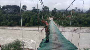 Jaga Keamanan Fasilitas Warga, Babinsa Rutin Pantau Jembatan Gantung di Musim Penghujan Tiba