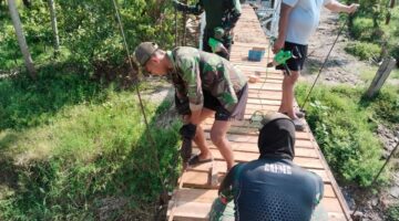 Babinsa Bersama Warga Pasang Papan Lantai Jembatan Gantung Perintis Akses Perekonomian Warga